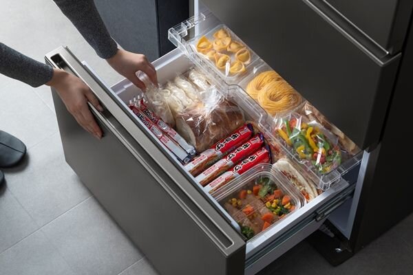 冷蔵庫の冷凍室を開ける女性