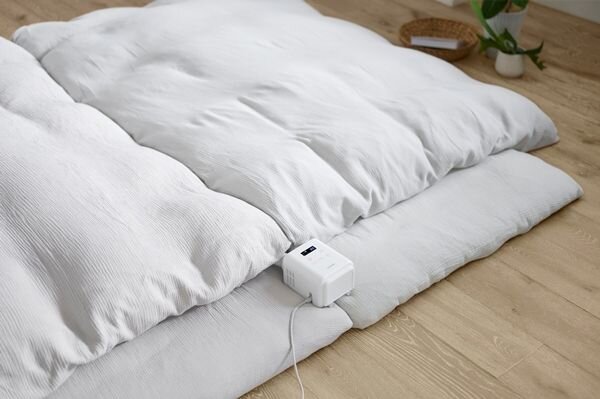 布団にセットされたツインノズルタイプの布団乾燥機