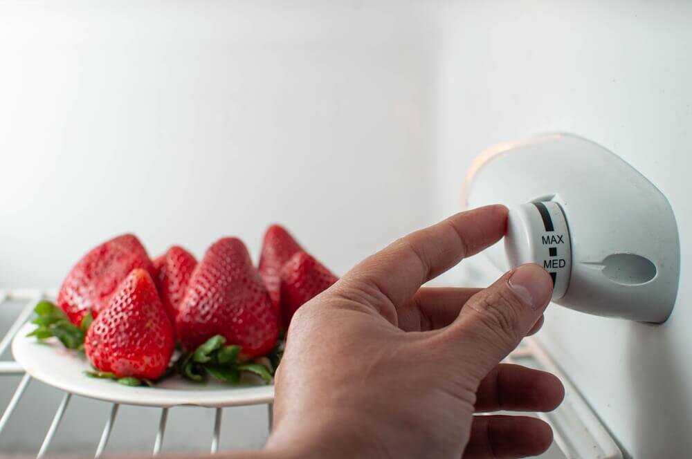 冷蔵庫の温度設定を切り替える人の手元