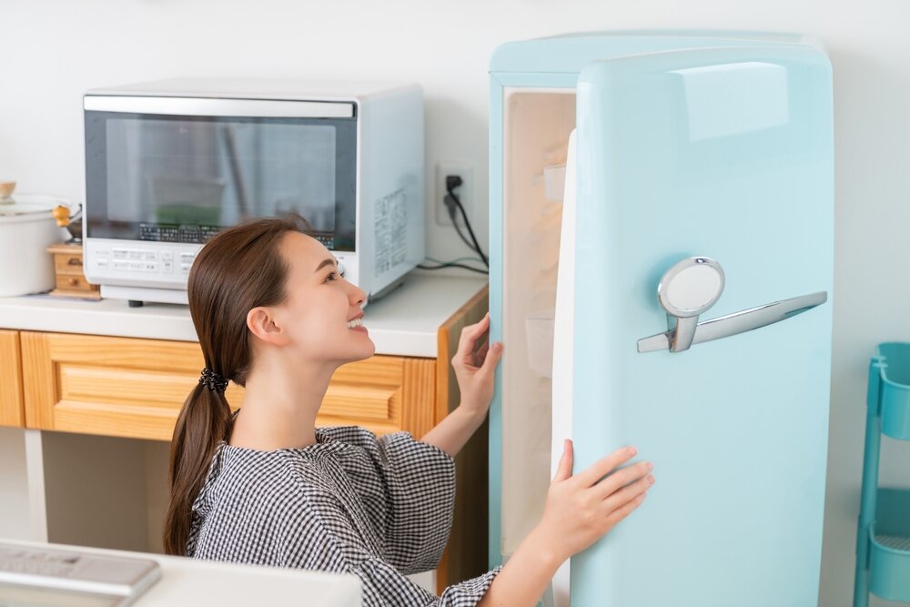 冷蔵庫の中をチェックする女性