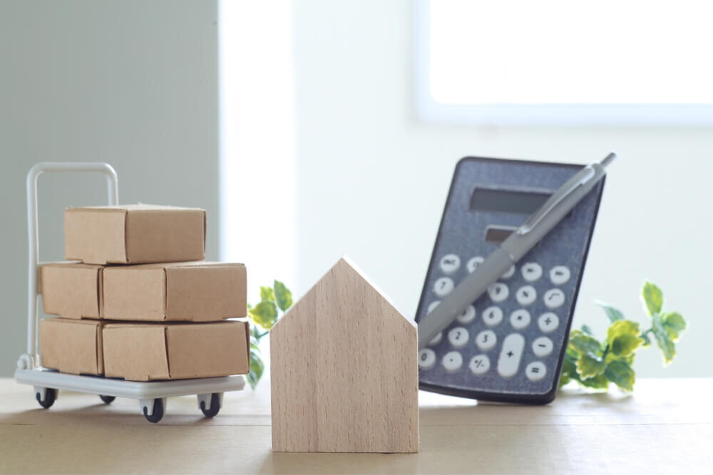 荷物と家の積み木、電卓とペン