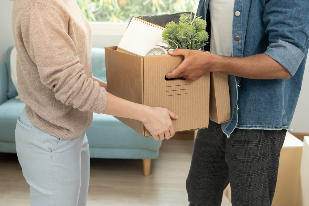 ダンボールボックスに入った荷物を渡す男女