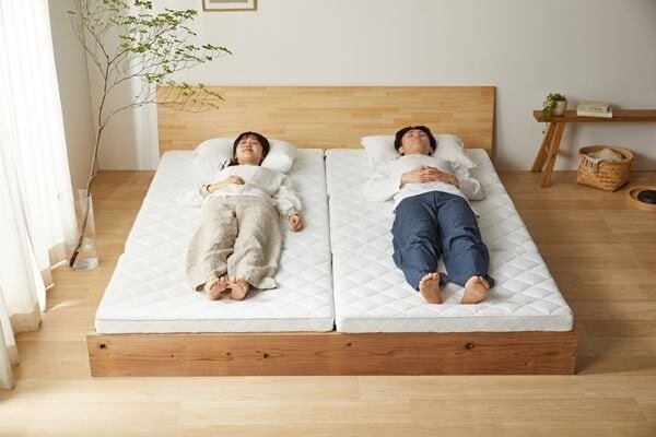 マットレスの上に寝転んでいる男女