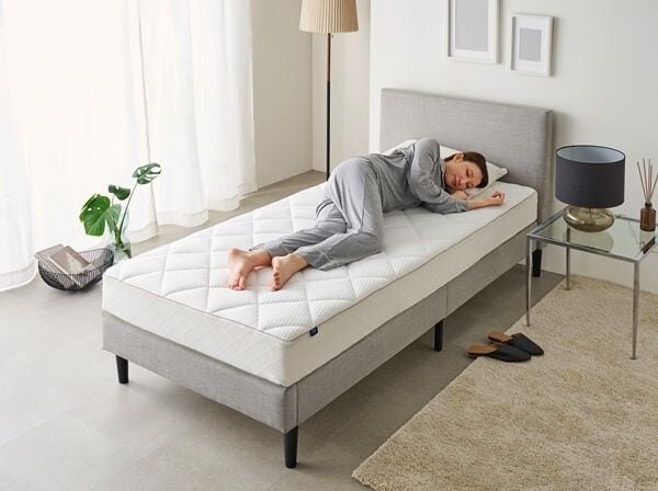 マットレスの上で寝ている女性