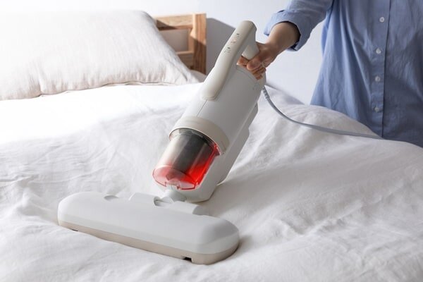 ふとんクリーナーを使用する女性