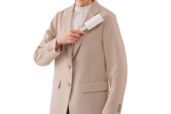 ハンディクリーナーで洋服のホコリを取る男性