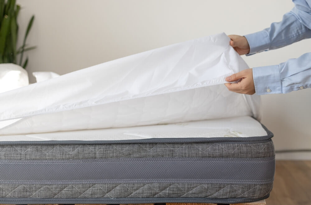 マットレスにシーツを敷く男性