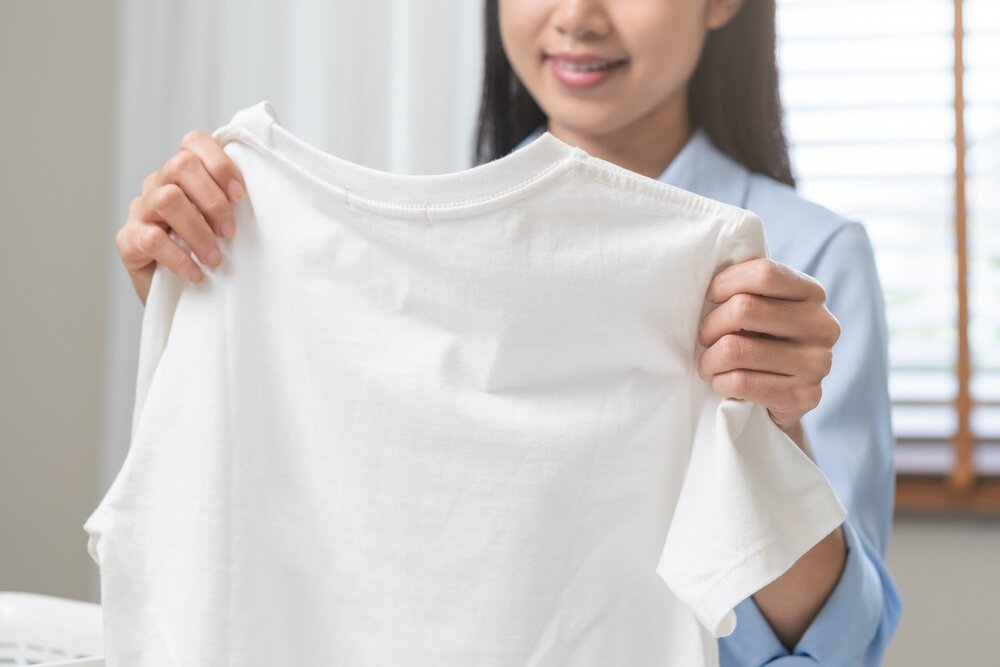 白いTシャツを持つ女性