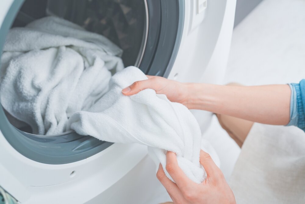 洗濯機から洗濯物を出す女性