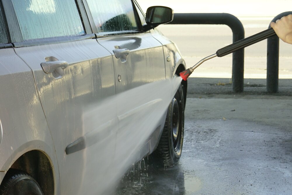 高圧洗浄機で車に水をかける様子