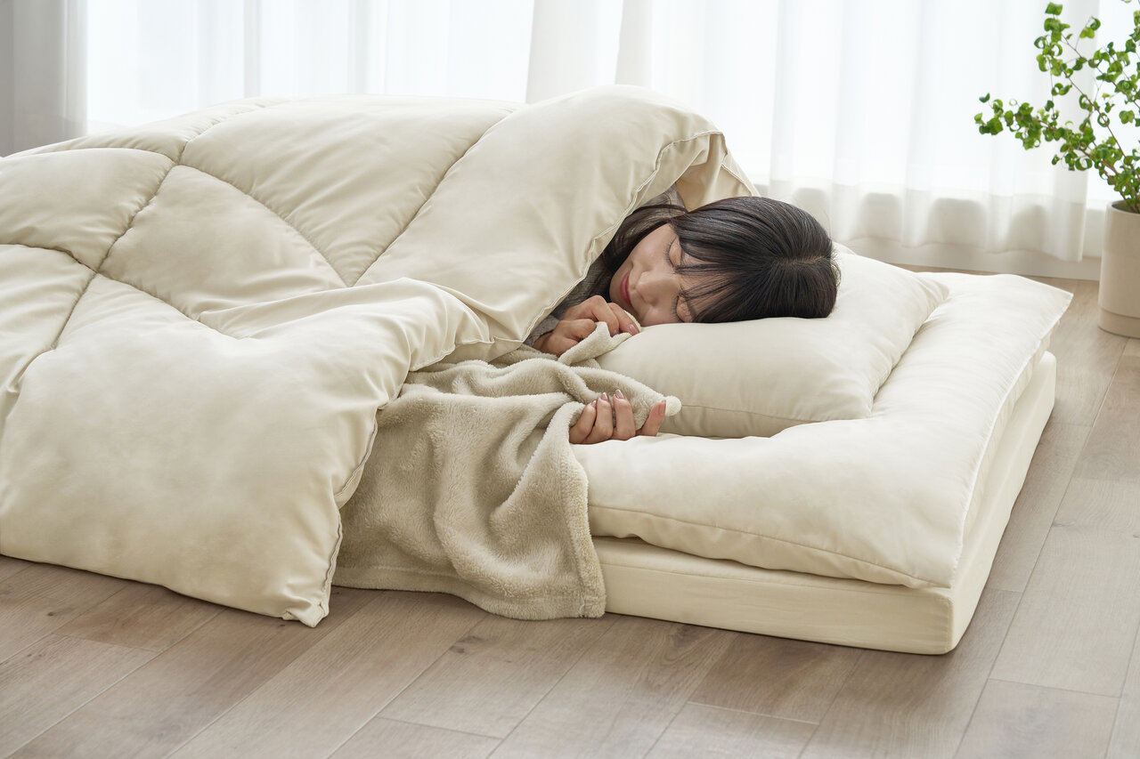 マットレスで寝る女性