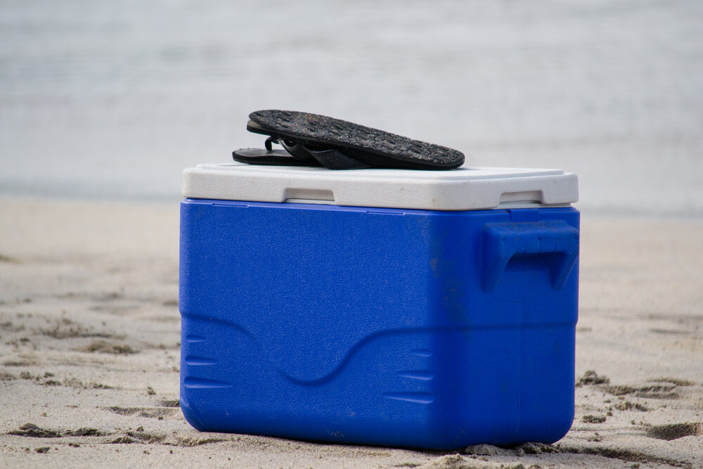 浜辺に置かれた青いクーラーボックス