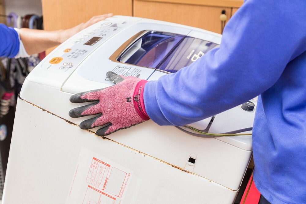 運び出される壊れた洗濯機