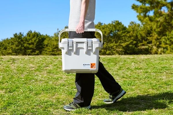 クーラーボックスを持ち運ぶ男性