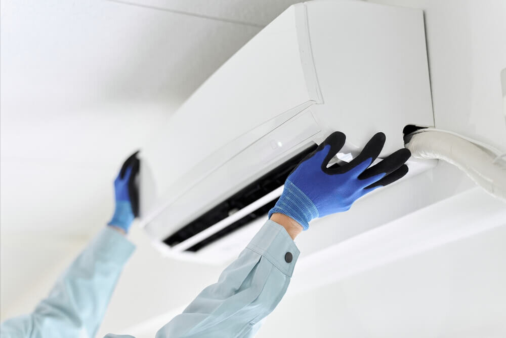 エアコンを確認する作業員の男性