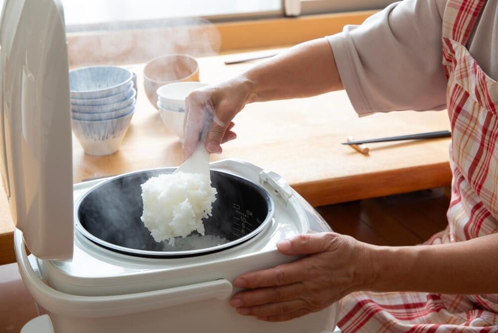 炊いたごはんをよそう女性の手