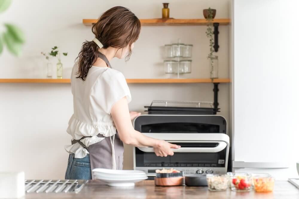 電子レンジで調理をする女性