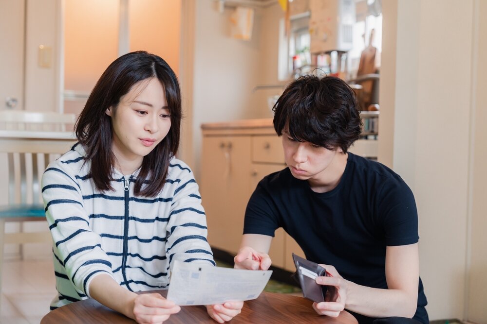 書類を見つめる若い夫婦