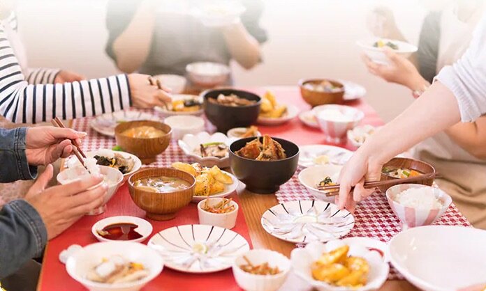 食卓を囲んで食事をする家族