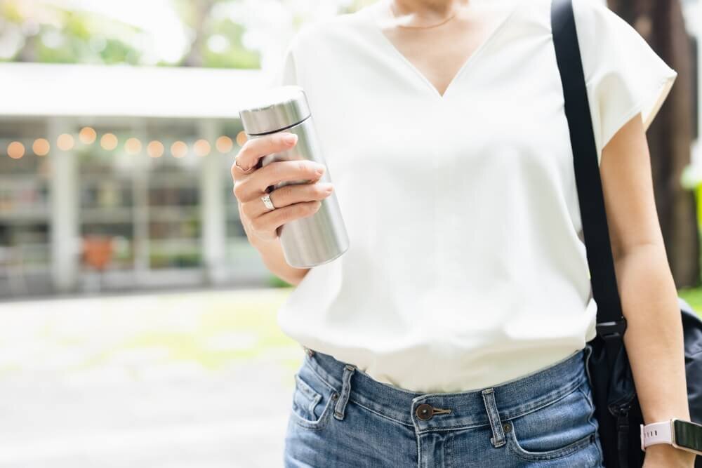 水筒を持って歩く女性