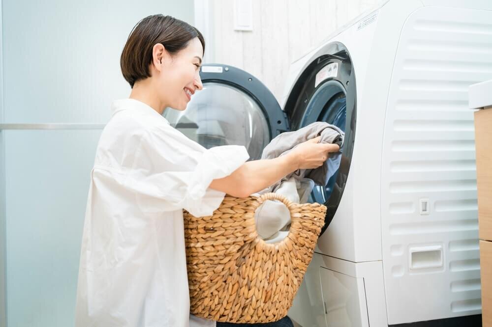 洗濯機から洗濯物を取り出す女性