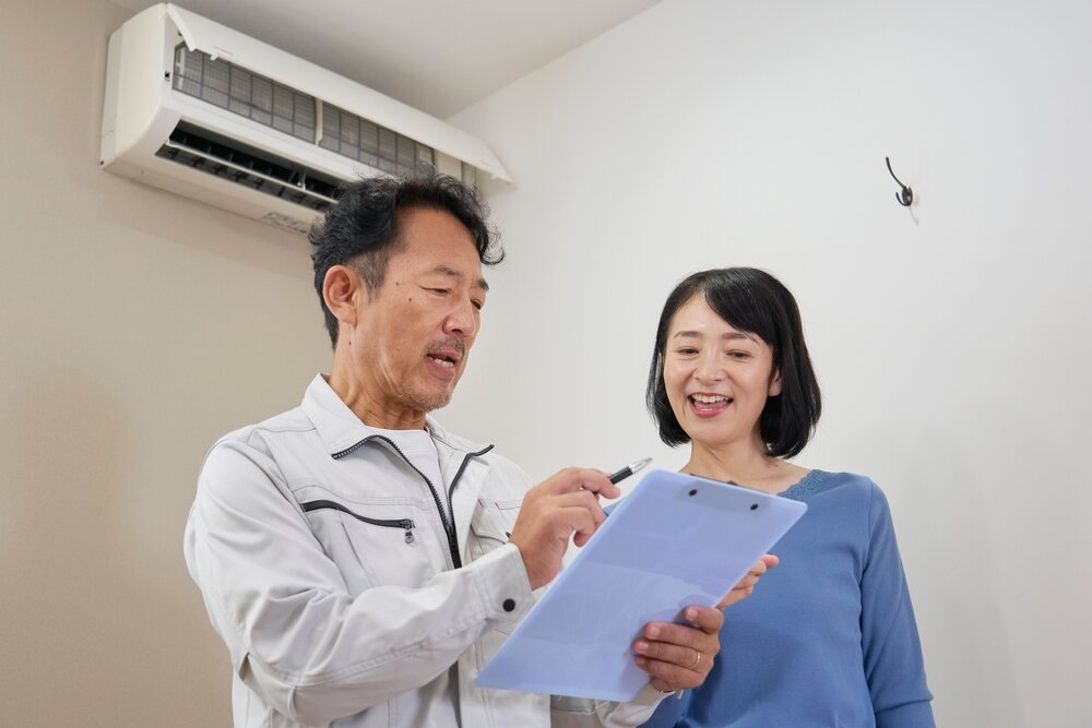 エアコンの話をしている業者と女性