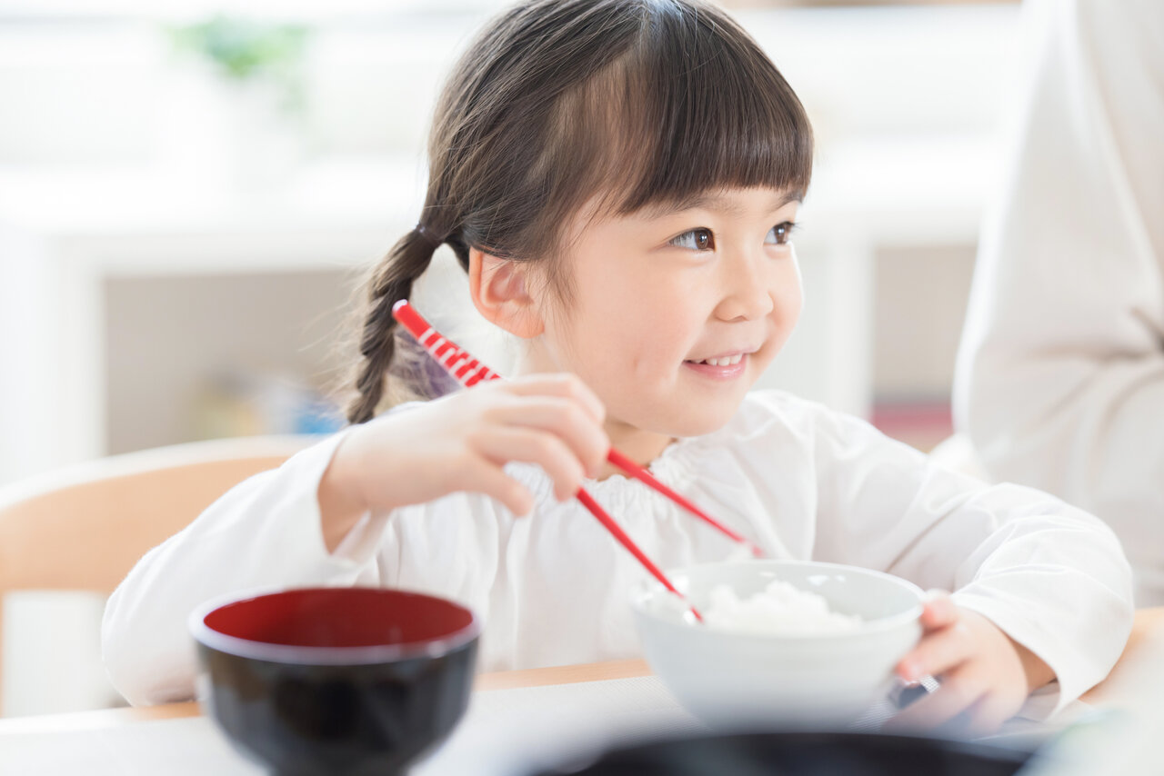 箸でご飯を食べる子ども