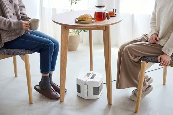 向かい合う2人の足元を暖めるセラミックファンヒーター