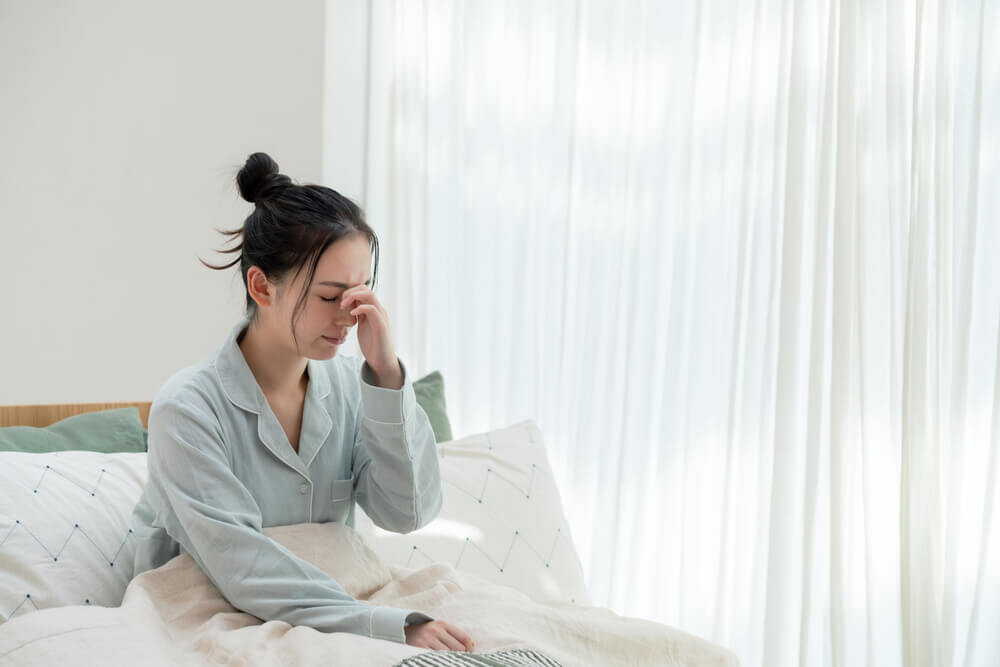 眉間に指を当てる女性