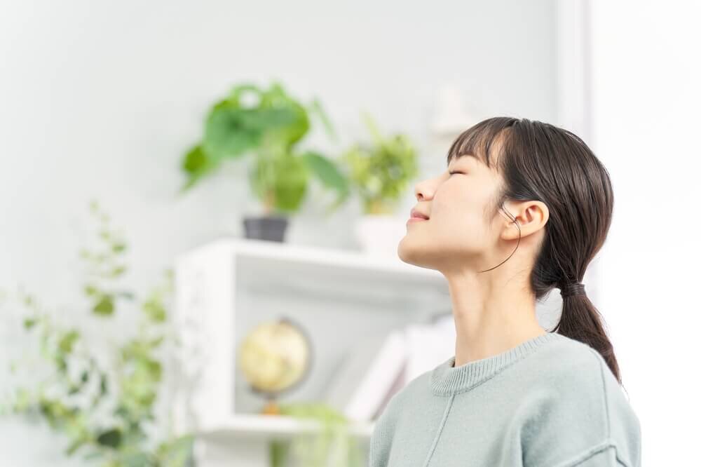 目を瞑って深呼吸する女性