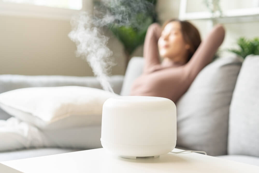 加湿器がついた部屋でくつろぐ女性