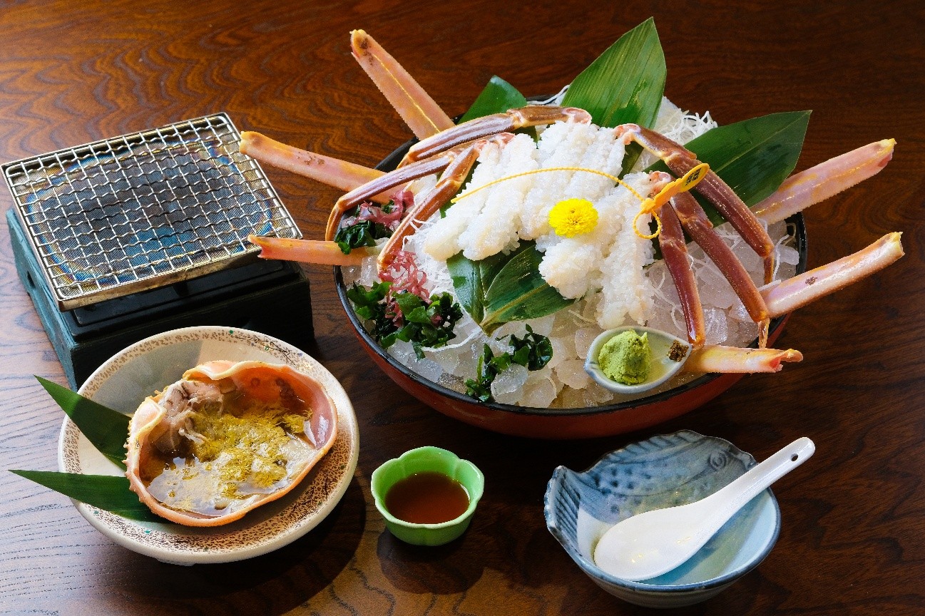 氷の上に盛り付けられた新鮮な越前がにの蟹刺しと蟹味噌