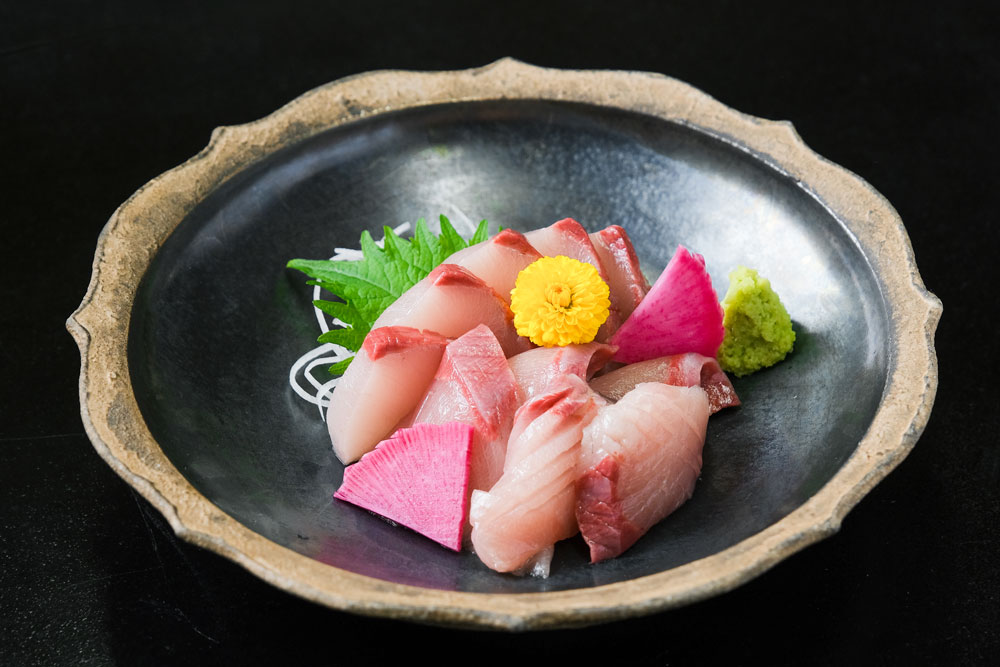 脂がのった寒ブリの刺身を皿に盛り付けた料理写真