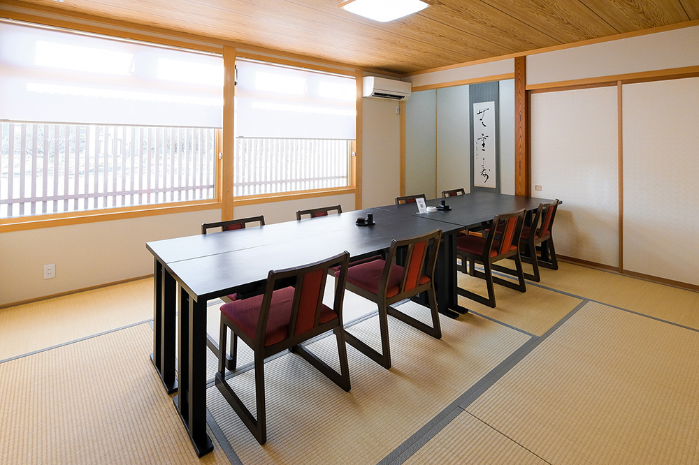 畳敷きの和室にテーブルと椅子を備えた客席