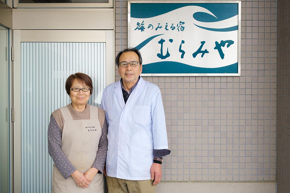 宿前に立つ、宿 むらみやを営む村宮さんご夫婦