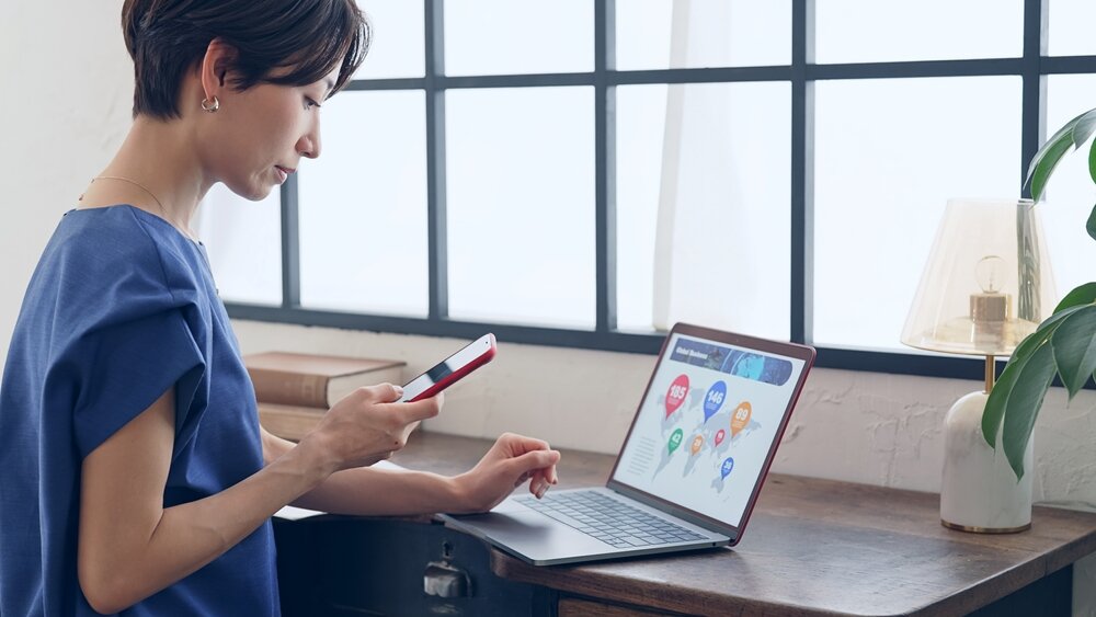 PCとスマホで作業する女性