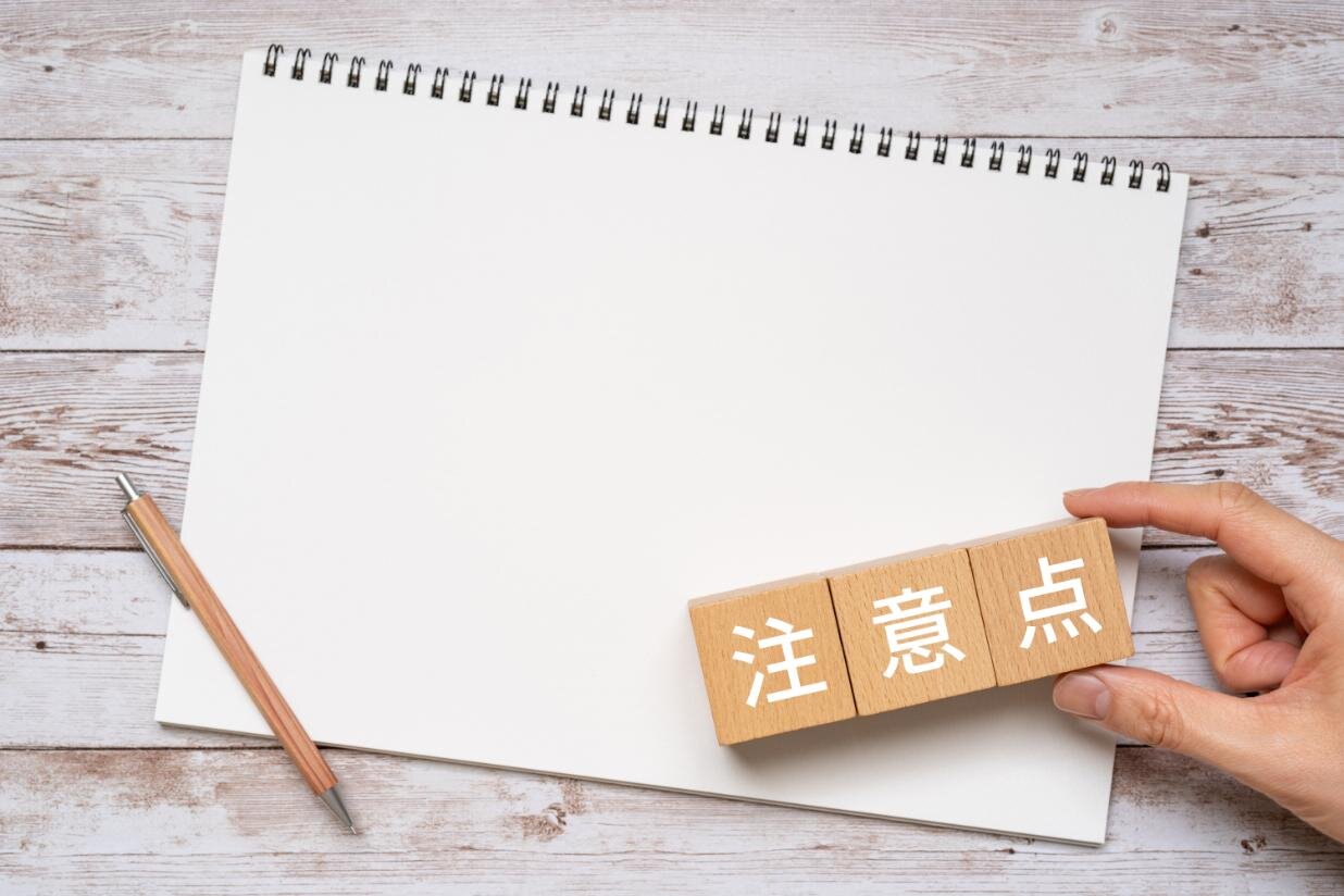 注意点と書かれたブロック・ノート・ペン・手
