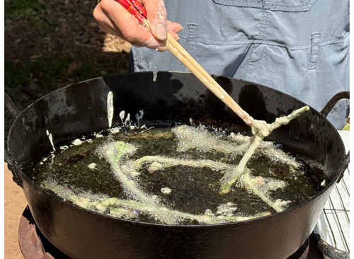 山菜を揚げる様子。