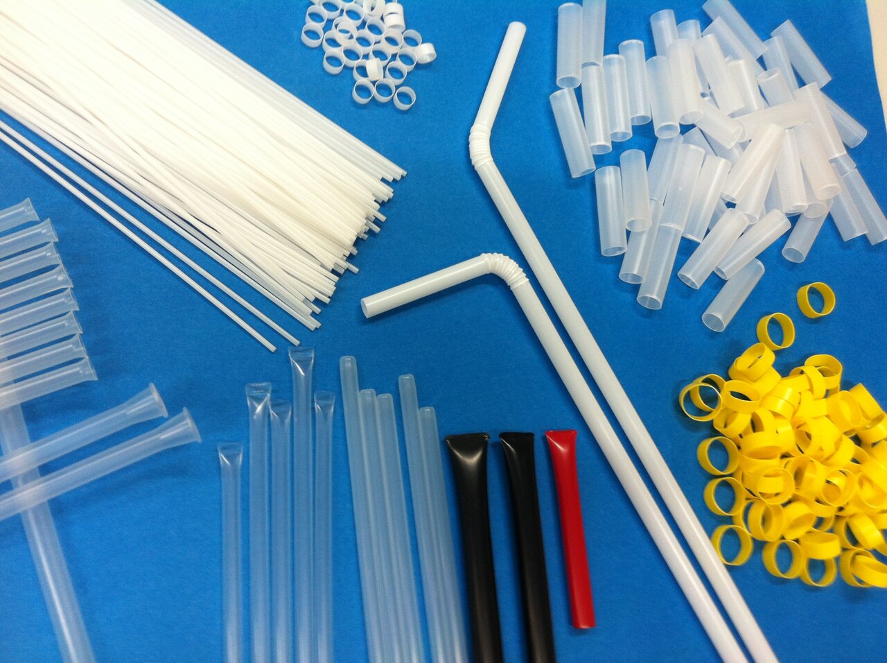 ストローを成形する様子（上）と口金から押し出されるストロー（下）。押出直後に水で冷却されて凝固する