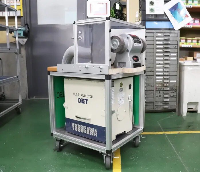 バリ取り機の集塵機台車と囲い。70代のベテランが改善提案で開発