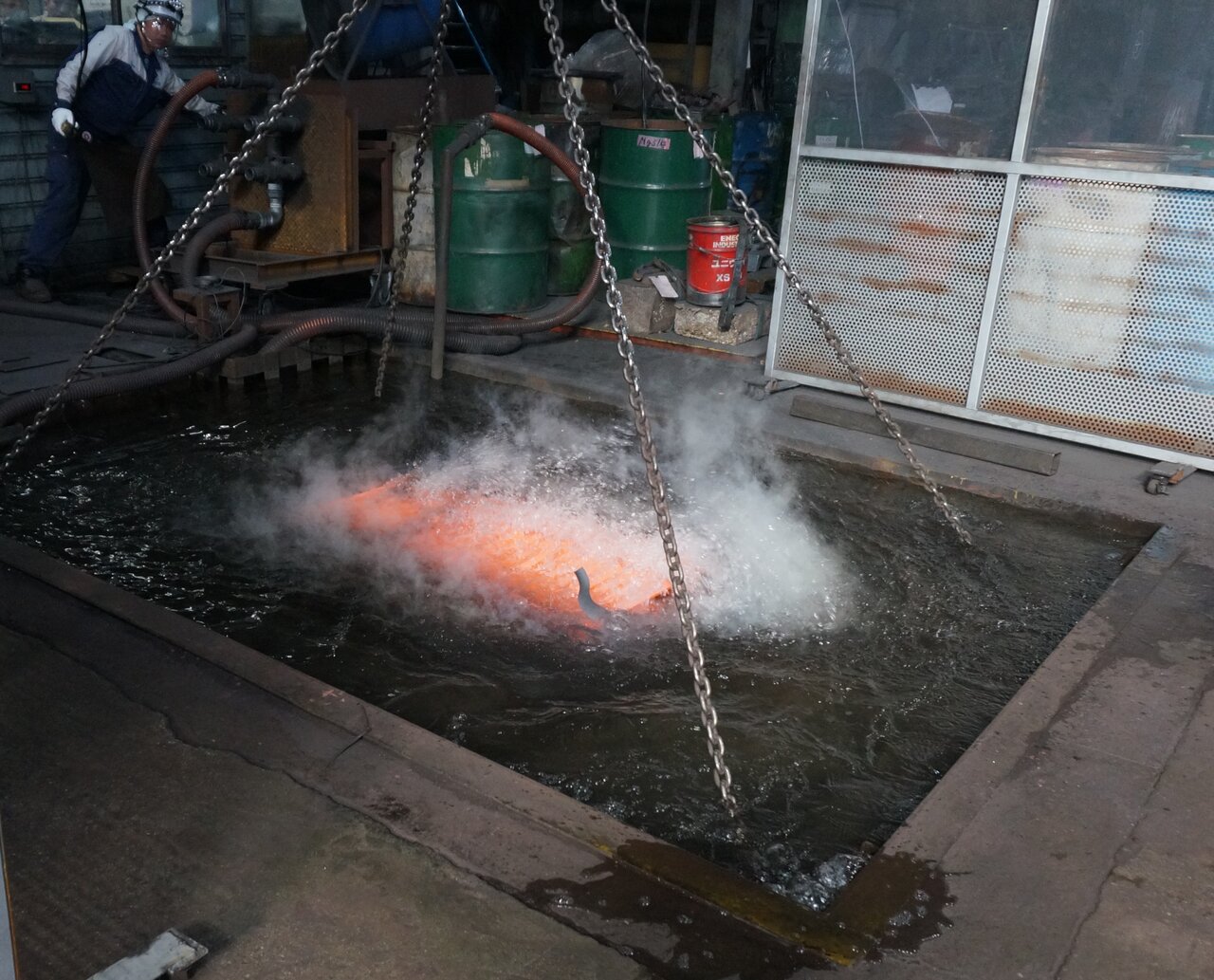 溶体化熱処理炉（上）からフォークリフトで材料を取り出し、水槽（下）で冷却する