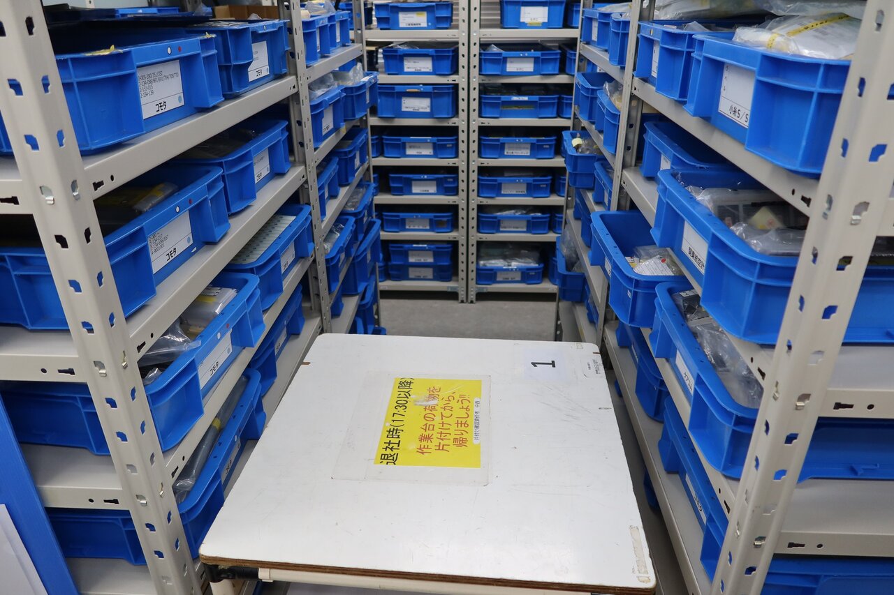整理整頓された在庫棚。トレイには年度シールが張られ、製造年度が一目でわかる