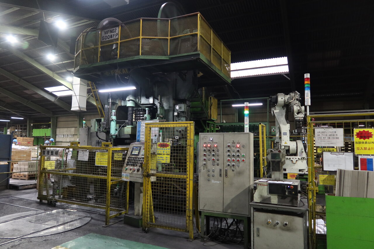 原料を混練した材料で耐火れんがを成形する自動プレス機