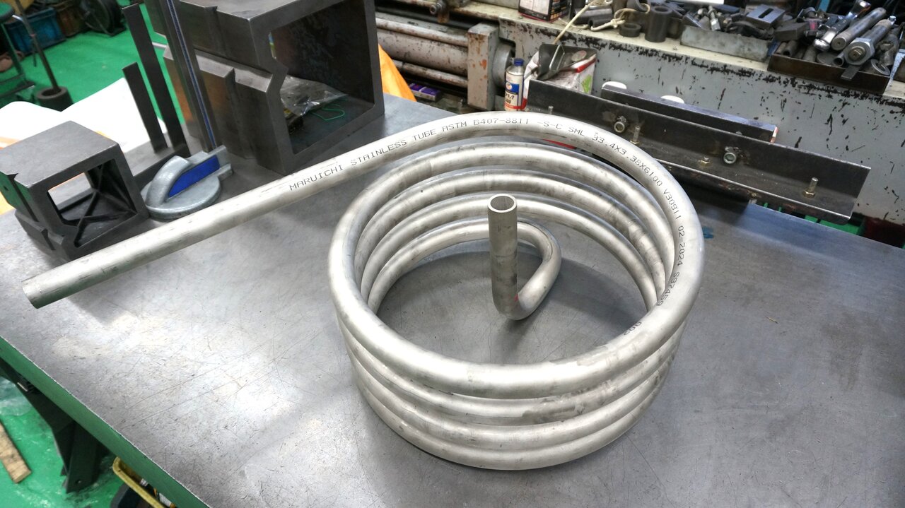 元は2部品を溶接していた熱交換装置部品を一体化し、長寿命化した例。パイプベンダー＋アングルベンダーで加工する