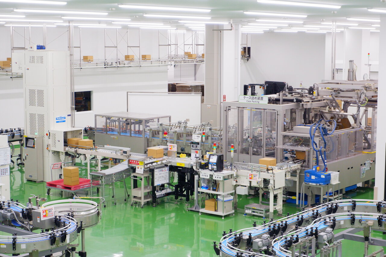 ケース詰め装置：生産ラインは箱詰めまですべて自動化。梱包した箱はそのまま垂直コンベアで倉庫へ搬入
