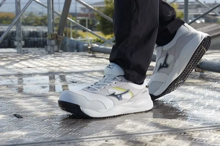 ミズノの白い安全靴を履いた人の足元の写真。靴はグレーと白の配色で、黒いソールが付いている。