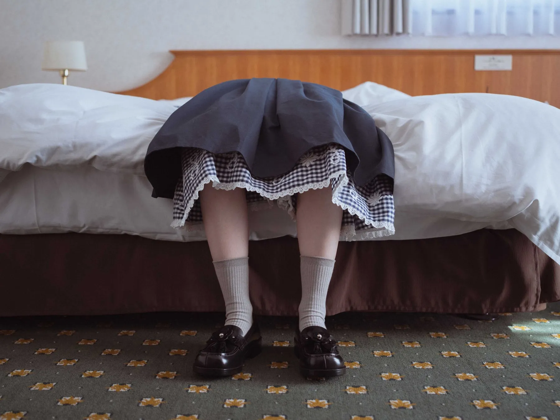 ベッドに顔を突っ込む女性の足元