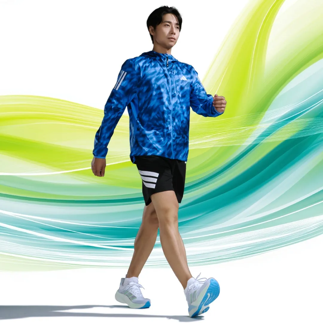 男性がスポーツウェアを着て歩いている様子が写っています。背景は抽象的な緑と青のグラデーションで、躍動感と爽やかさを演出しています。