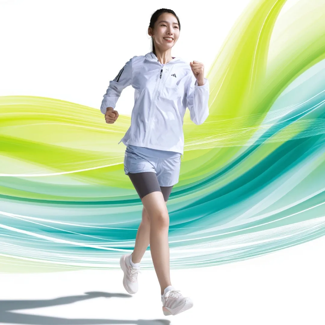 白いスポーツウェアを着て走っている女性の画像。背景は緑と青のグラデーション。