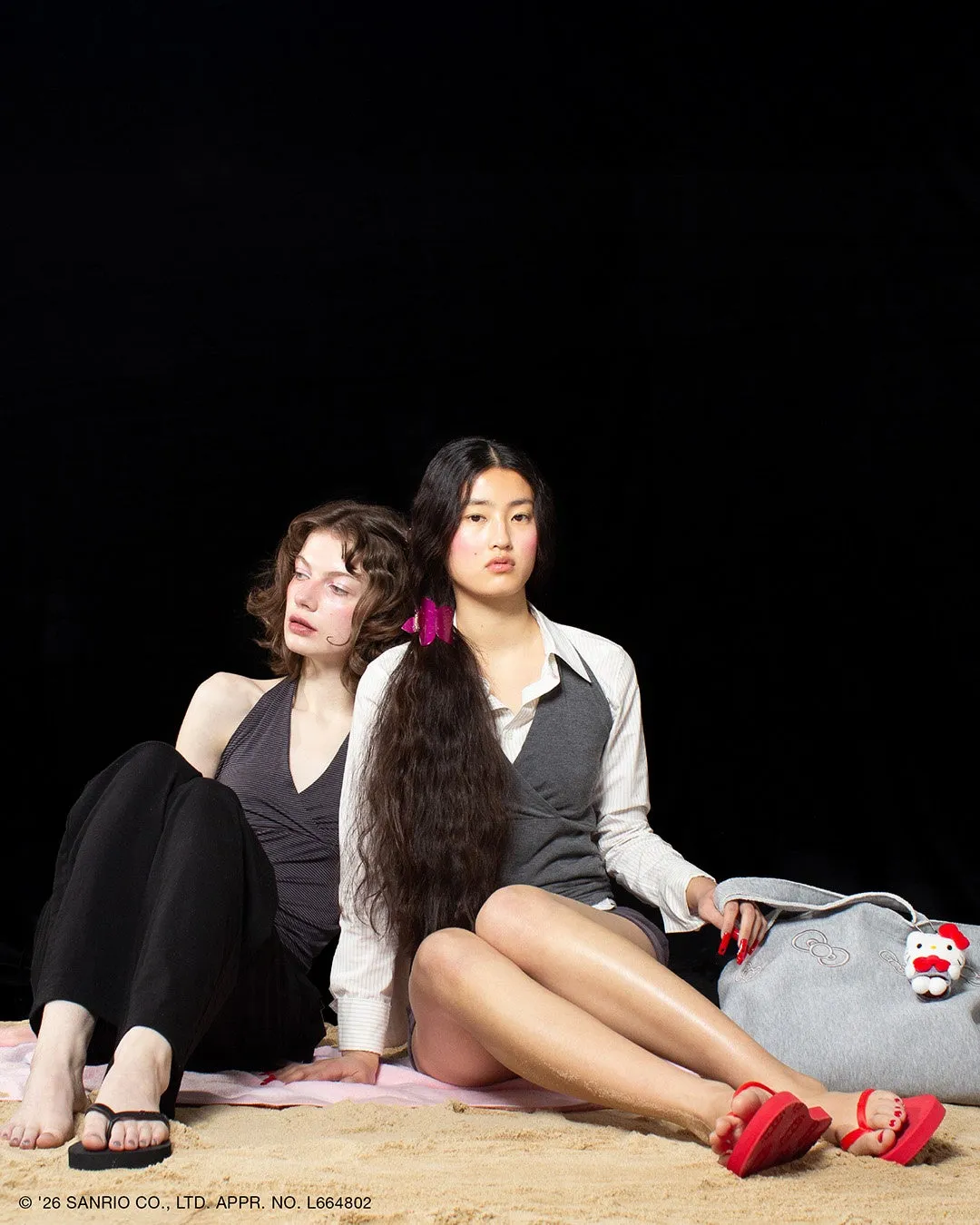 砂浜に座っている2人の女性の画像